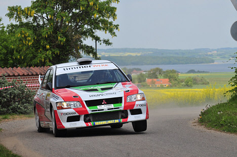 Med Horsens Fjord i baggrunden tordner Kim Madsen og Kasper Sørensen gennem landsbyen Skjold på vej mod sjettepladsen i Tegee Dan Rally i deres Mitsubishi Lancer Evo 7.
